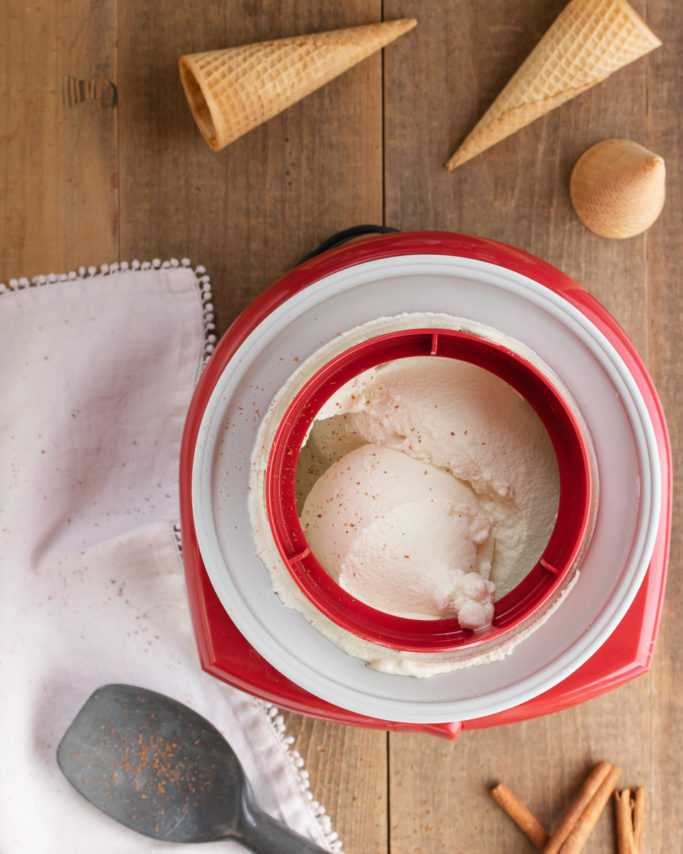 cuisinart ice cream maker with cinnamon tea ice cream inside and some ice cream cones