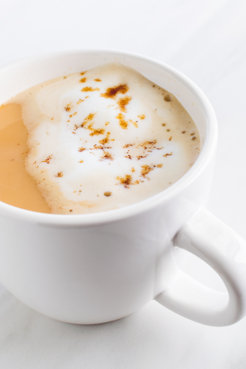 brown sugar milk tea served hot with frothy milk and sprinkled brown sugar bits