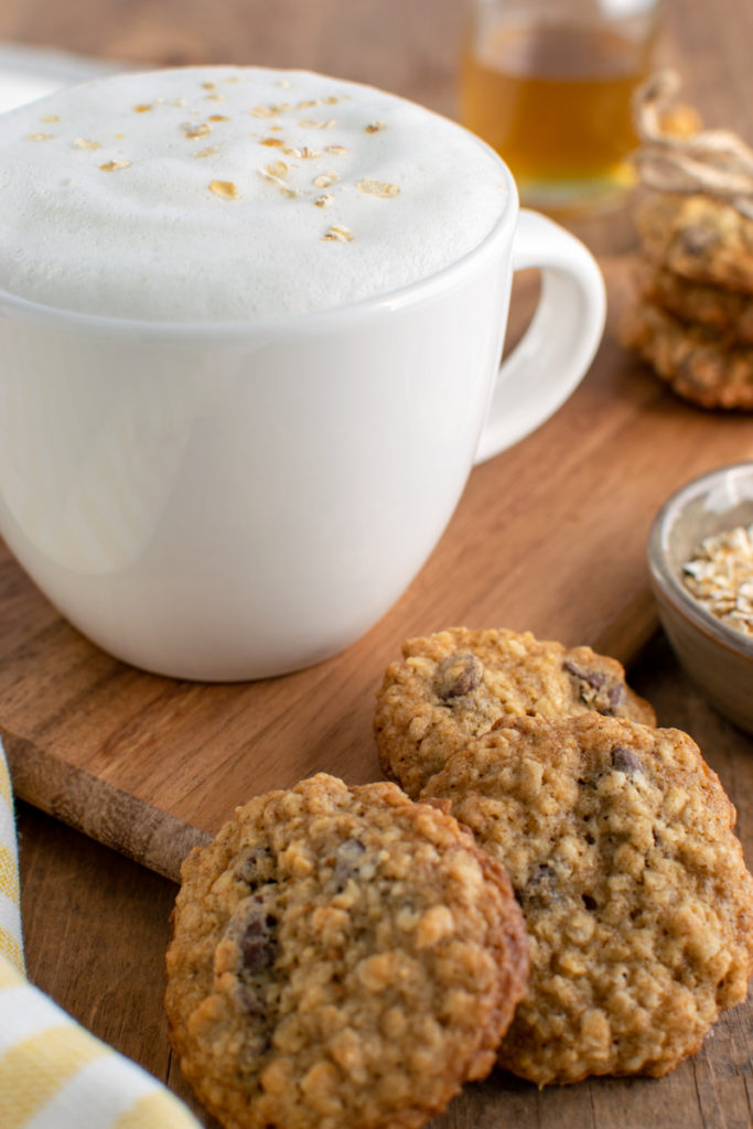 honey oat milk latte, a jar of honey simple syrup and oatmeal cookies