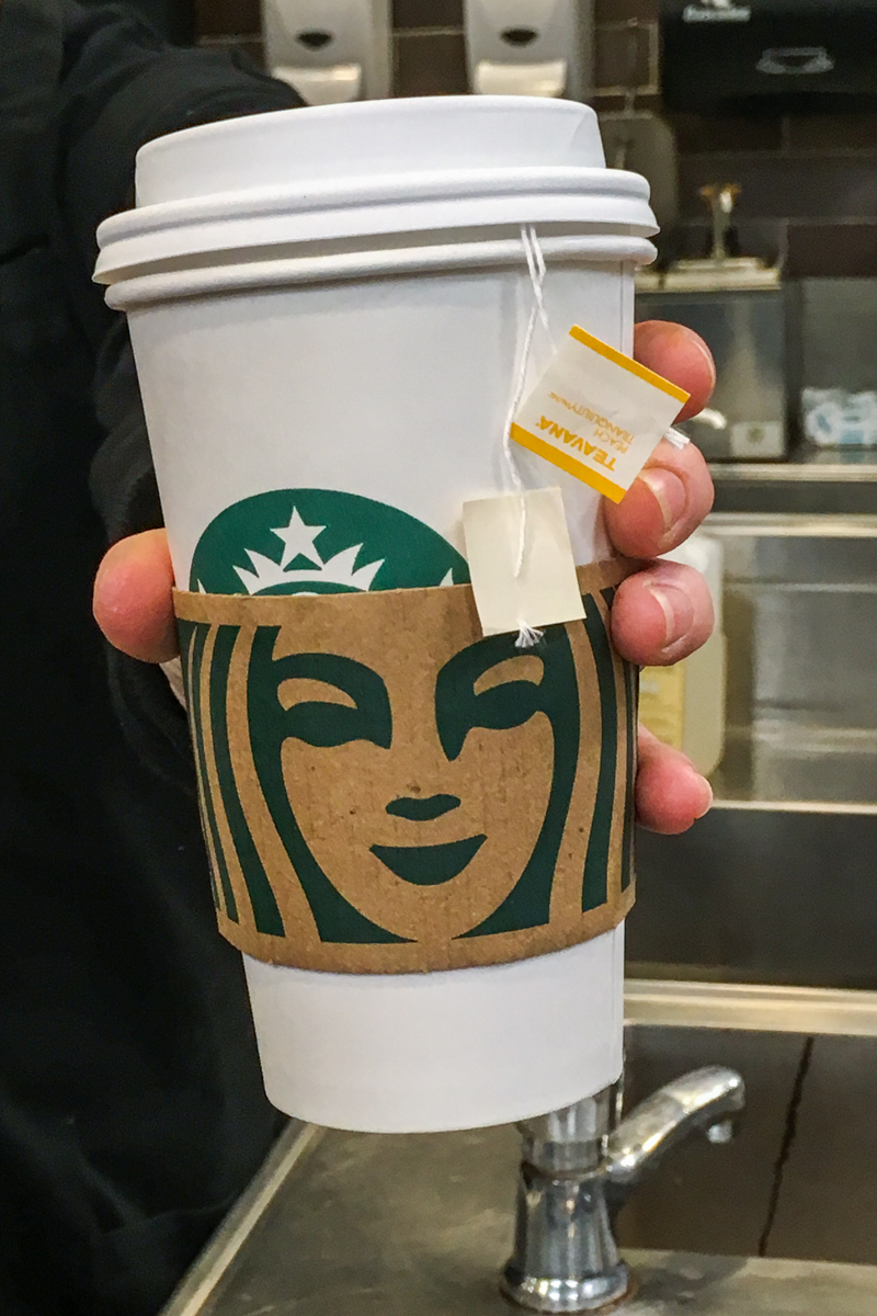 starbucks hot tea in barista's hand