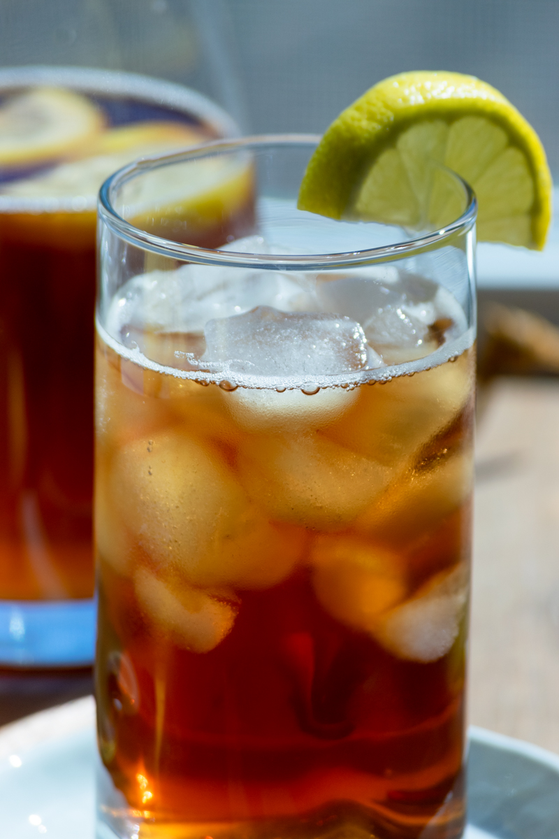 lemon iced tea in glass with lemon wedge