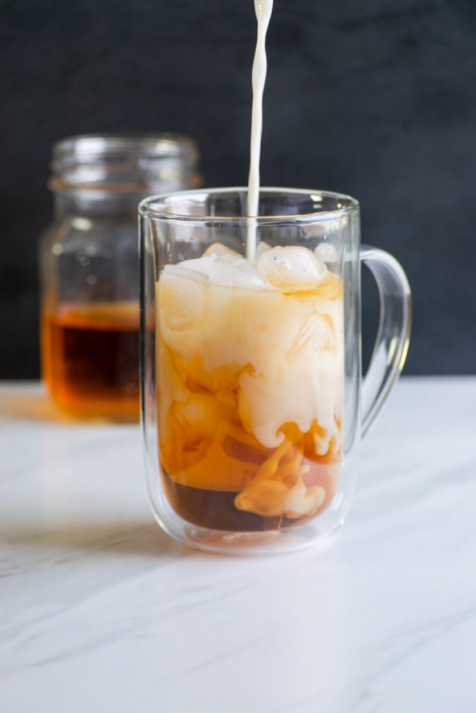 adding milk to cold brew earl grey tea to make london fog latte