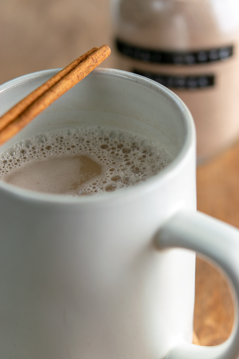 chai latte in a mug with cinnamon stick