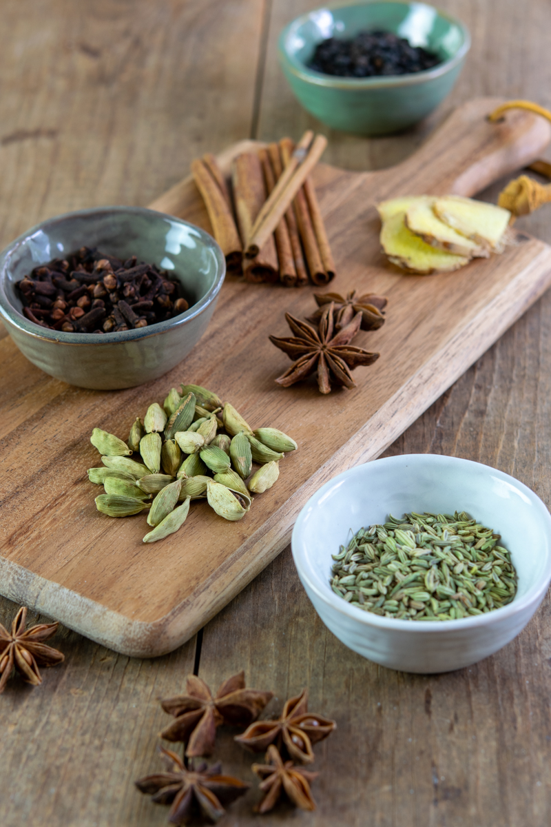 whole spices like star anise, green cardamom, fennel seeds, black peppercorns, cinnamon sticks, and cloves