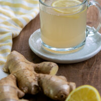 cup of fresh ginger tea, ginger root and lemon