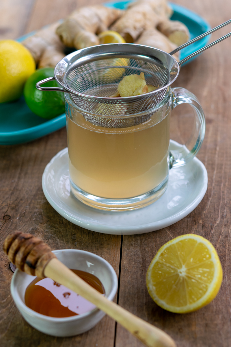 straining adrak chai into mug with small fine mesh strainer