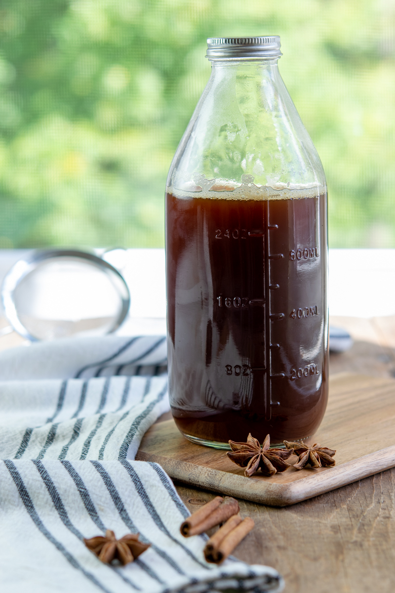 bottle of chai concentrate, star anise and cinnamon sticks