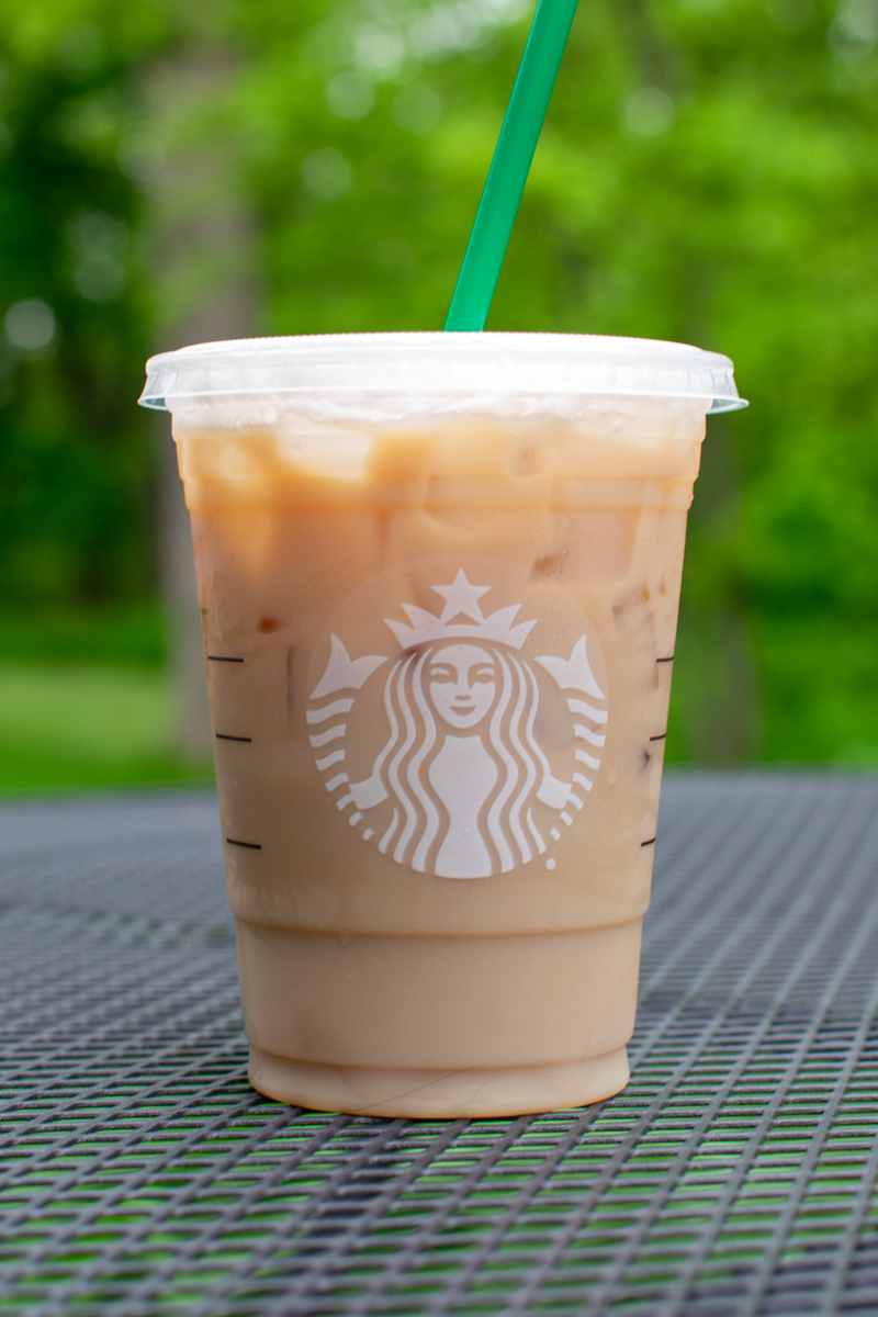 iced chai latte in a starbucks cold cup on a table outside