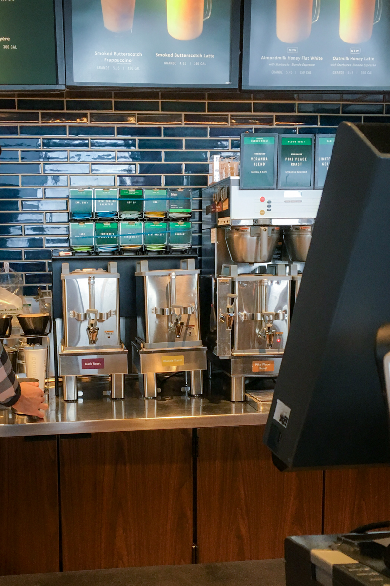 teavana tea bags hanging on wall behind starbucks counter