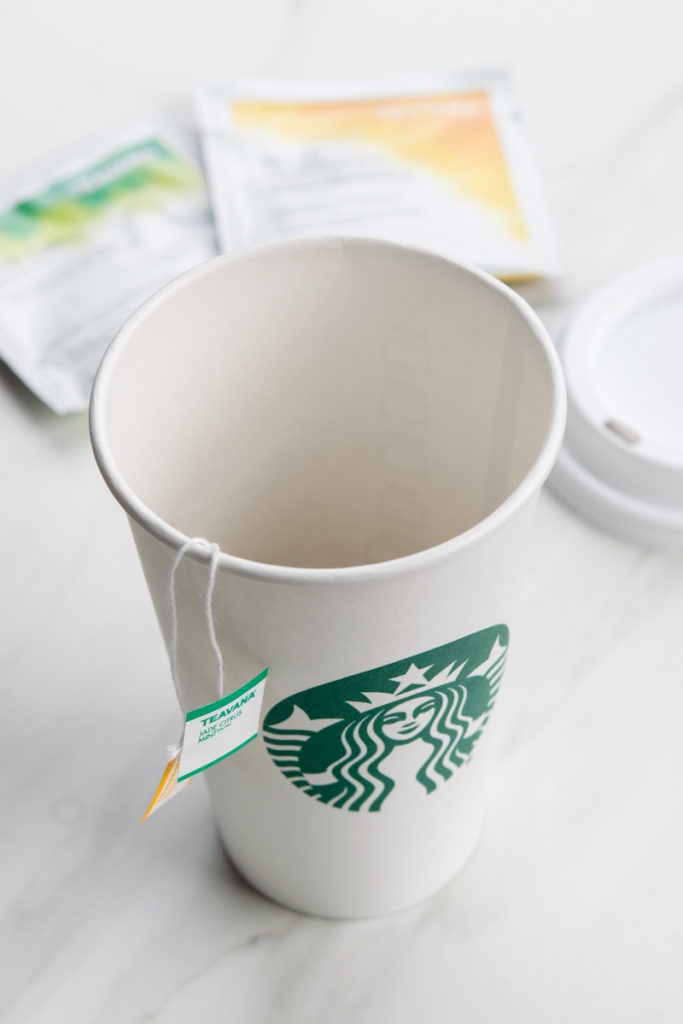 Empty starbucks cup and two teavana tea bags to make honey citrus mint tea.