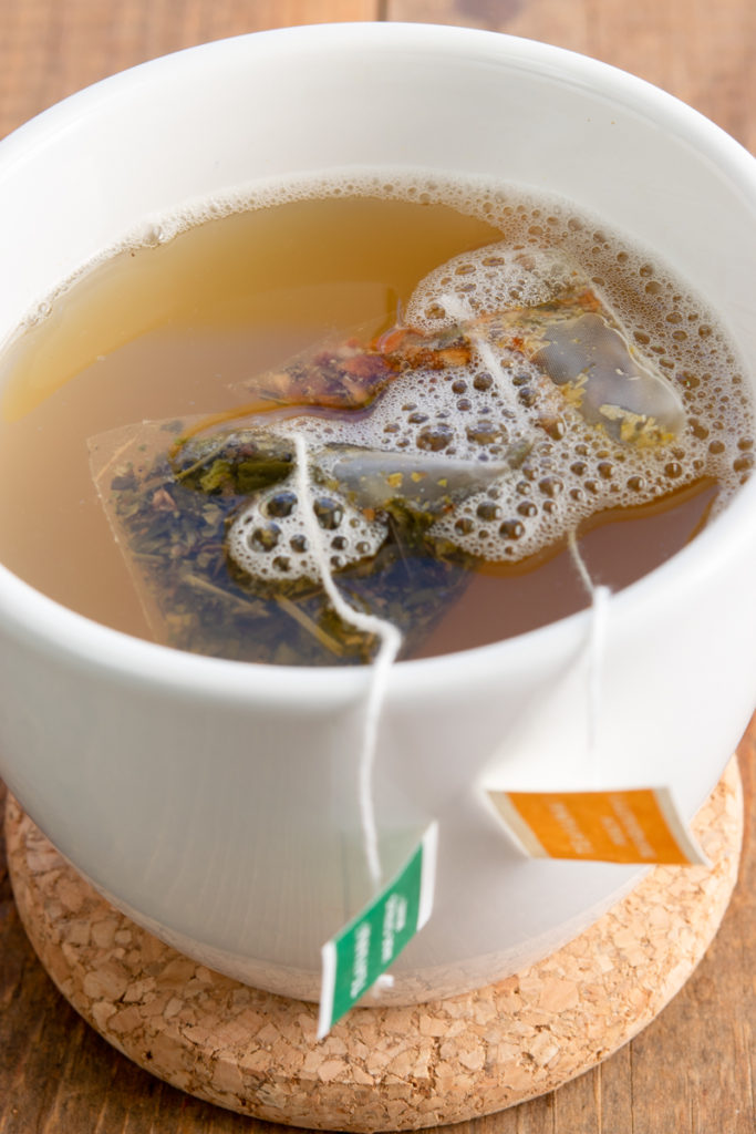 Steaming cup of homemade Honey Citrus Mint tea.