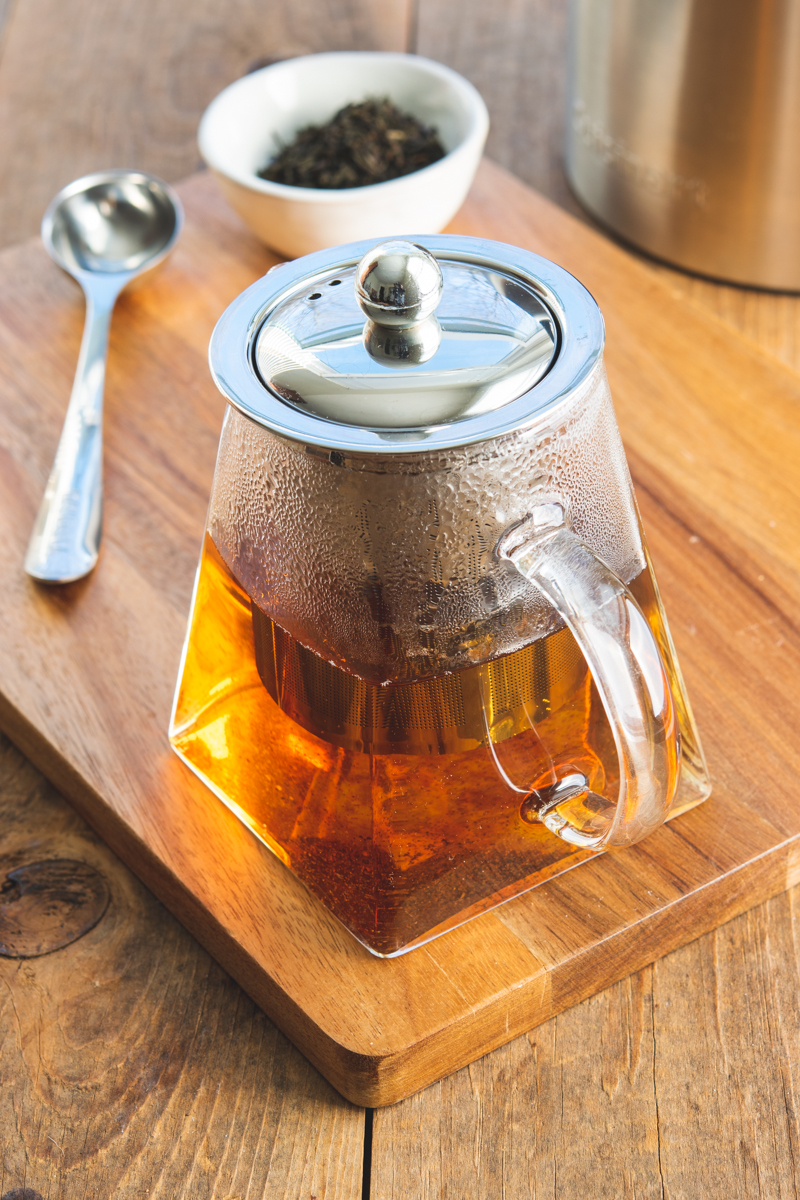 steeping loose tea in a glass tea kettle that has an infuser basket inside