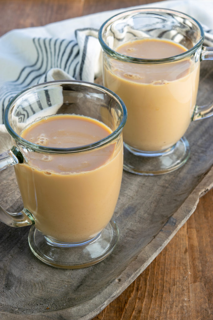 pouring milk into mugs to make tea lattes