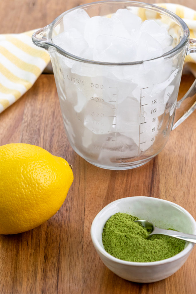 lemon, matcha powder and cup of ice cubes