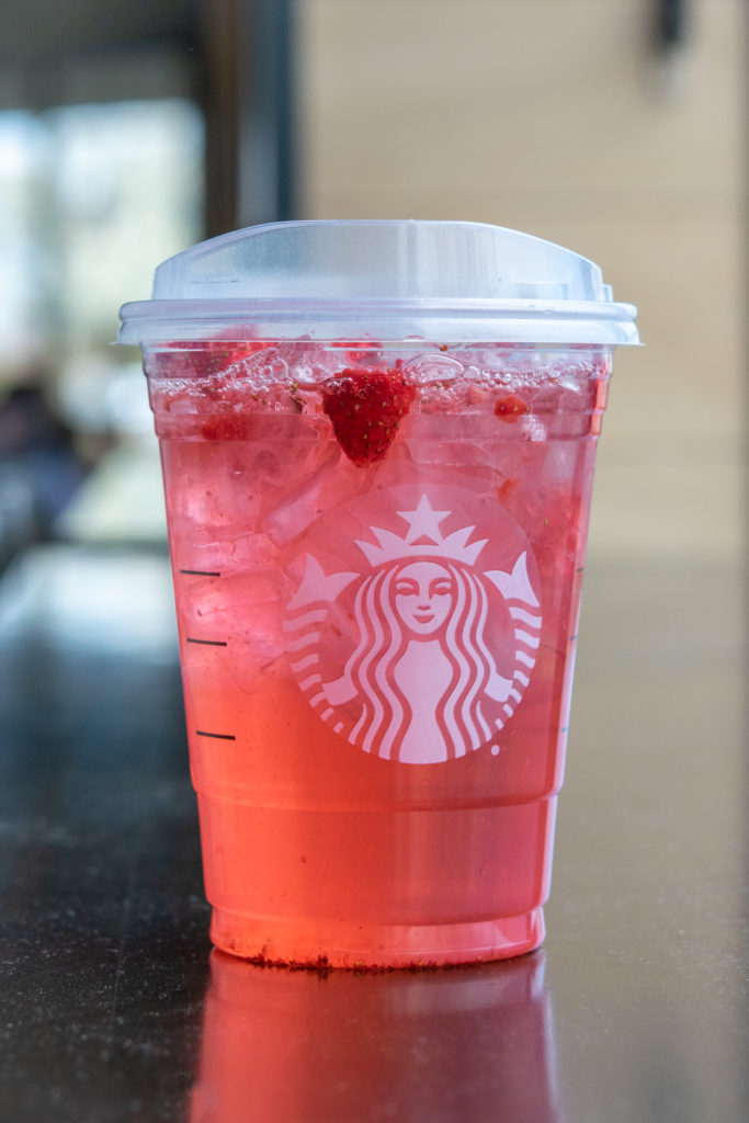 Strawberry Acai Refresher sitting on Starbucks counter.