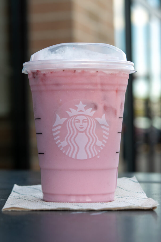 A Keto Pink Drink from Starbucks made with passion tango tea, heavy cream, sugar-free syrup and strawberries.