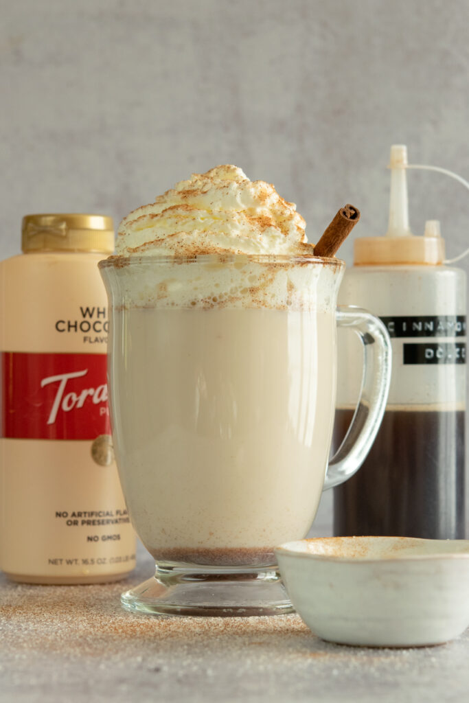 DIY Starbucks snickerdoodle hot cocoa and bottles of white chocolate sauce and cinnamon dolce syrup.