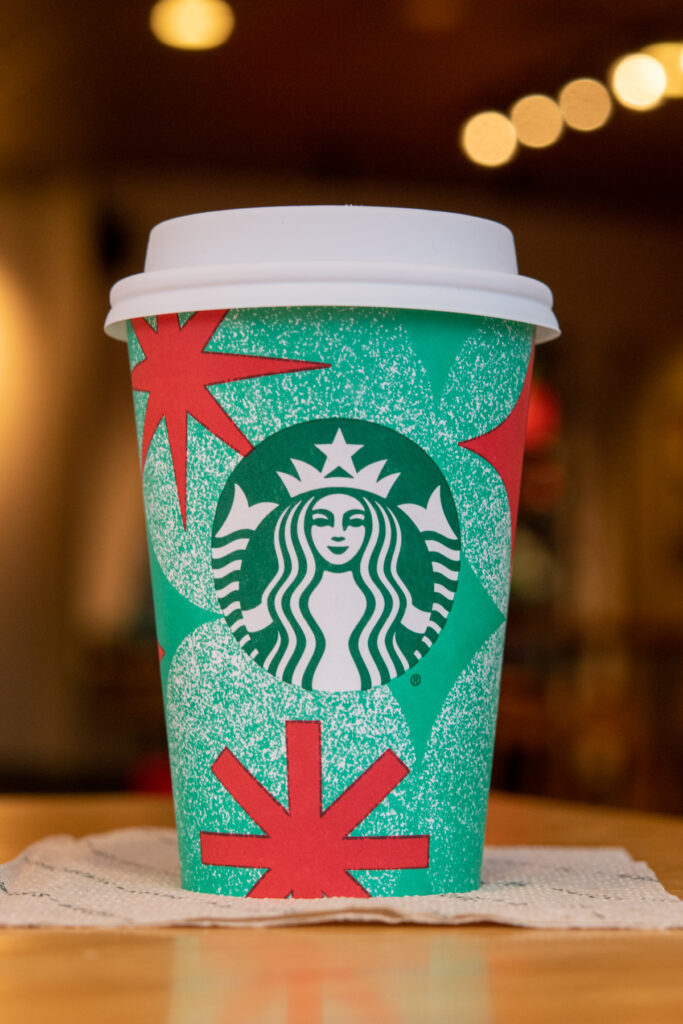 A customized chestnut praline chai latte at Starbucks in a festive cup.