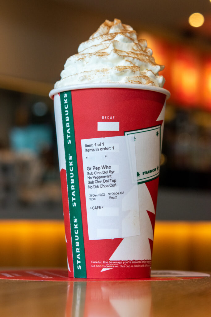 Starbucks Snickerdoodle Hot Chocolate with order sticker showing on red holiday cup.