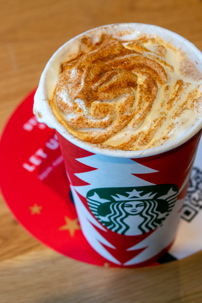 Starbucks Snickerdoodle white hot chocolate with whipped cream melting into hot cocoa.