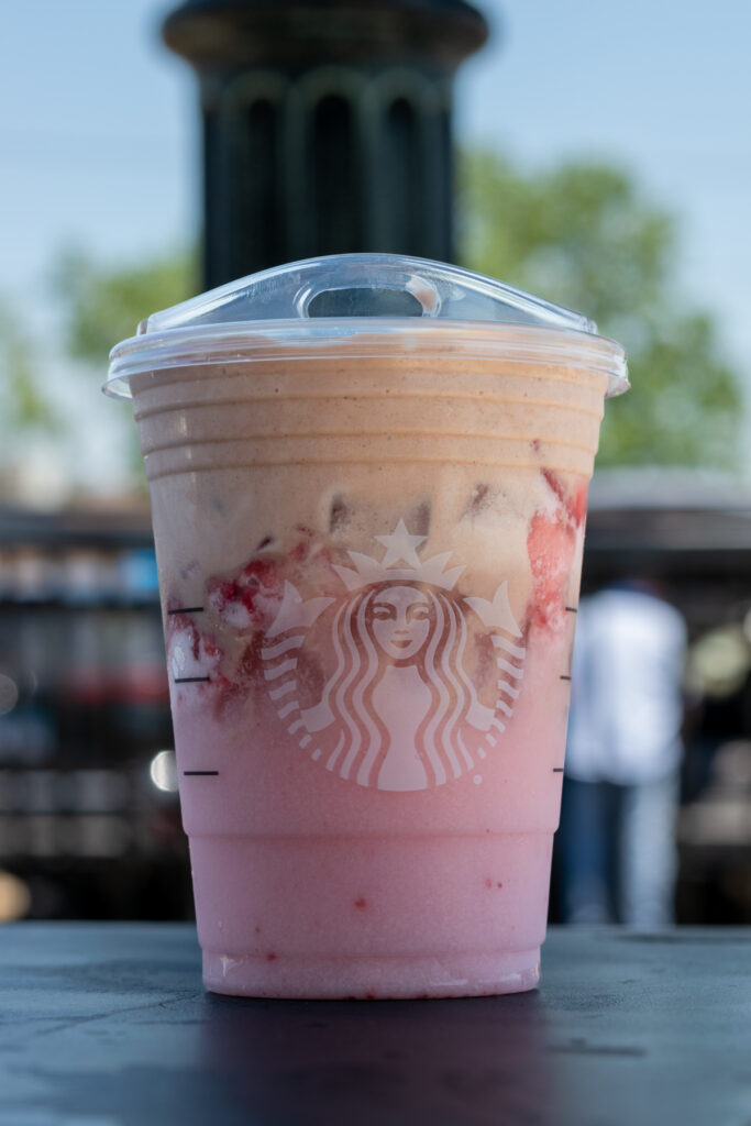 Pink Drink with mocha cold foam sitting on an outside table at Starbucks.