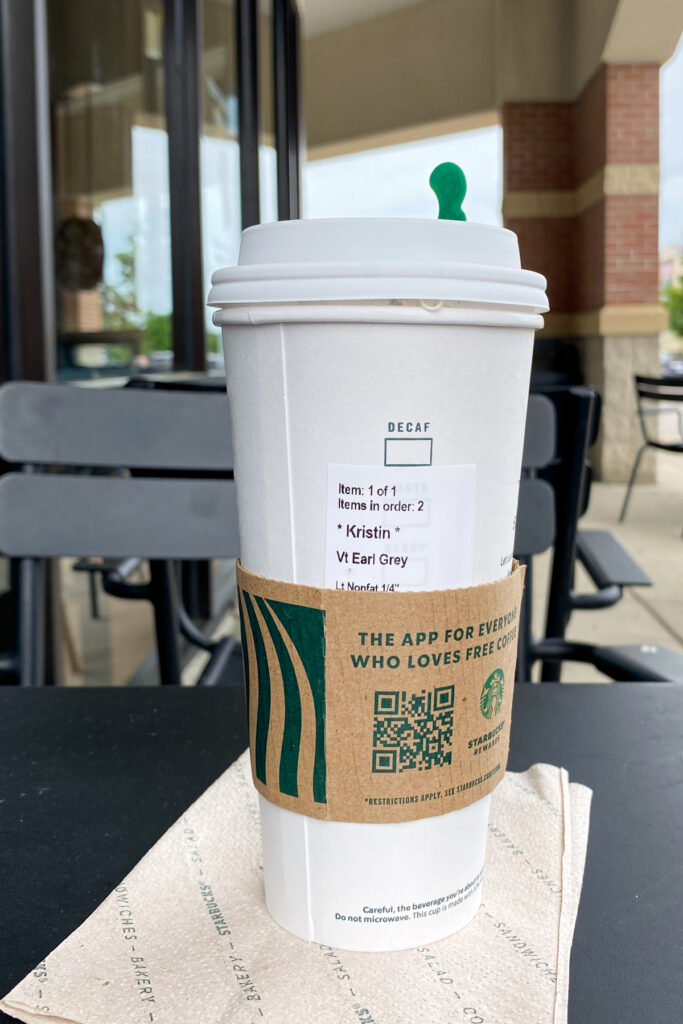 Starbucks Earl Grey Hot Tea on a napkin and outdoor table.