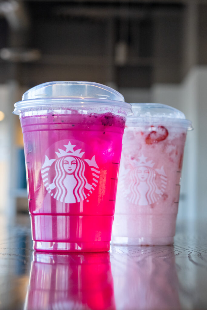 A Starbucks Mango Dragonfruit Refresher in front of a Strawberry Acai Pink Drink.