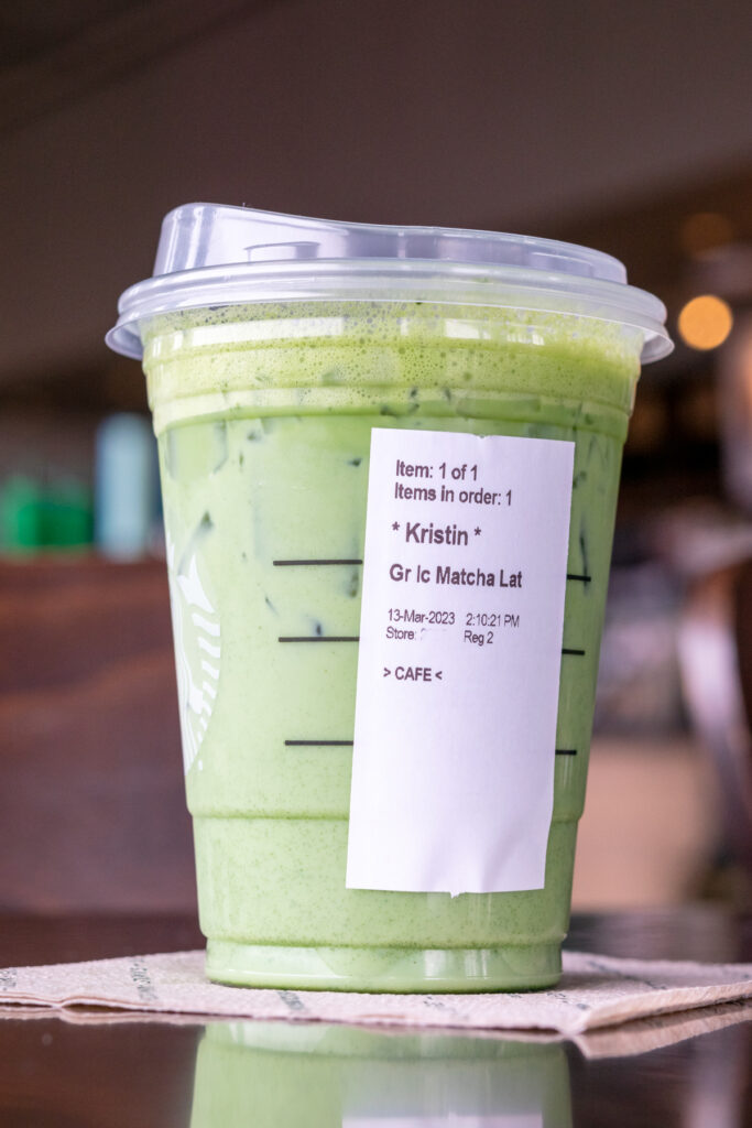 A grande Starbucks matcha latte with the order sticker showing on the side of the cup.
