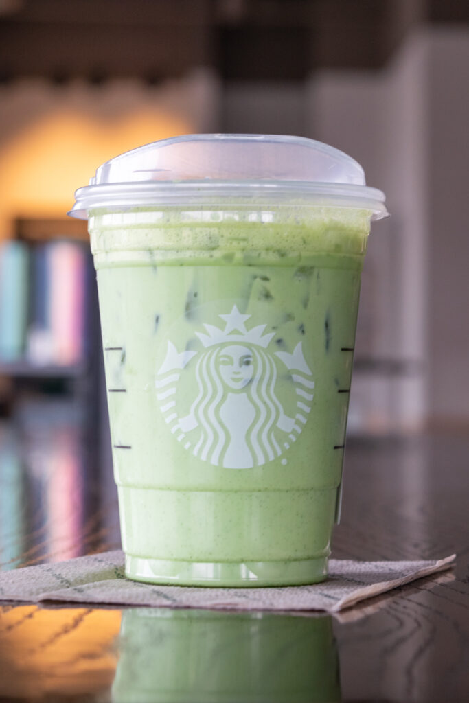 A Starbucks iced matcha latte on a table inside Starbucks.