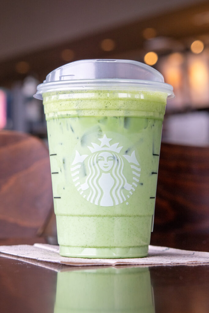 A Starbucks iced matcha latte on a table inside a Starbucks store.