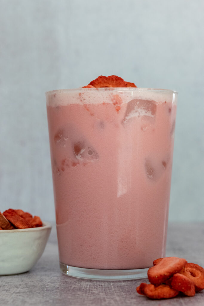 Copycat Starbucks Pink Drink in a glass with extra strawberries on top.