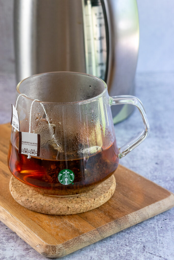 Two earl grey tea bags steeping in a Starbucks mug to make a London Fog tea latte.