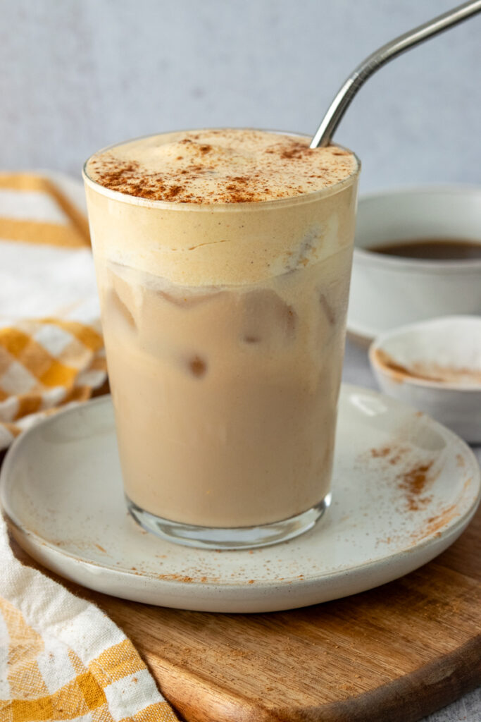 Homemade iced chai tea latte with pumpkin cold foam and pumpkin pie spice sprinkled on top.