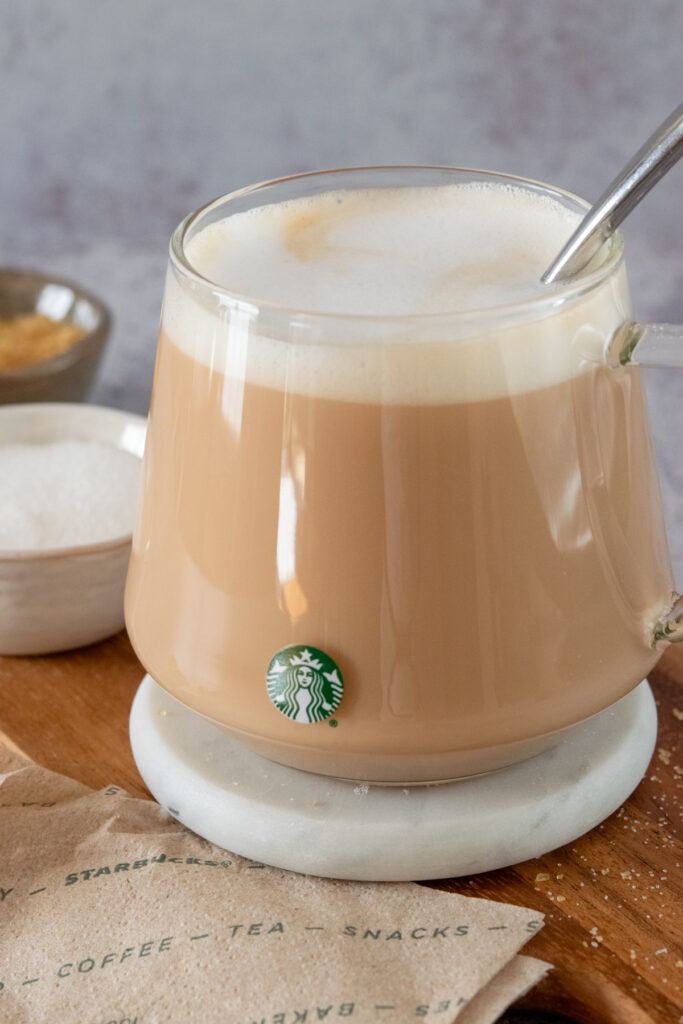 Homemade English Breakfast tea latte in a Starbucks mug sitting next to a Starbucks napkin.