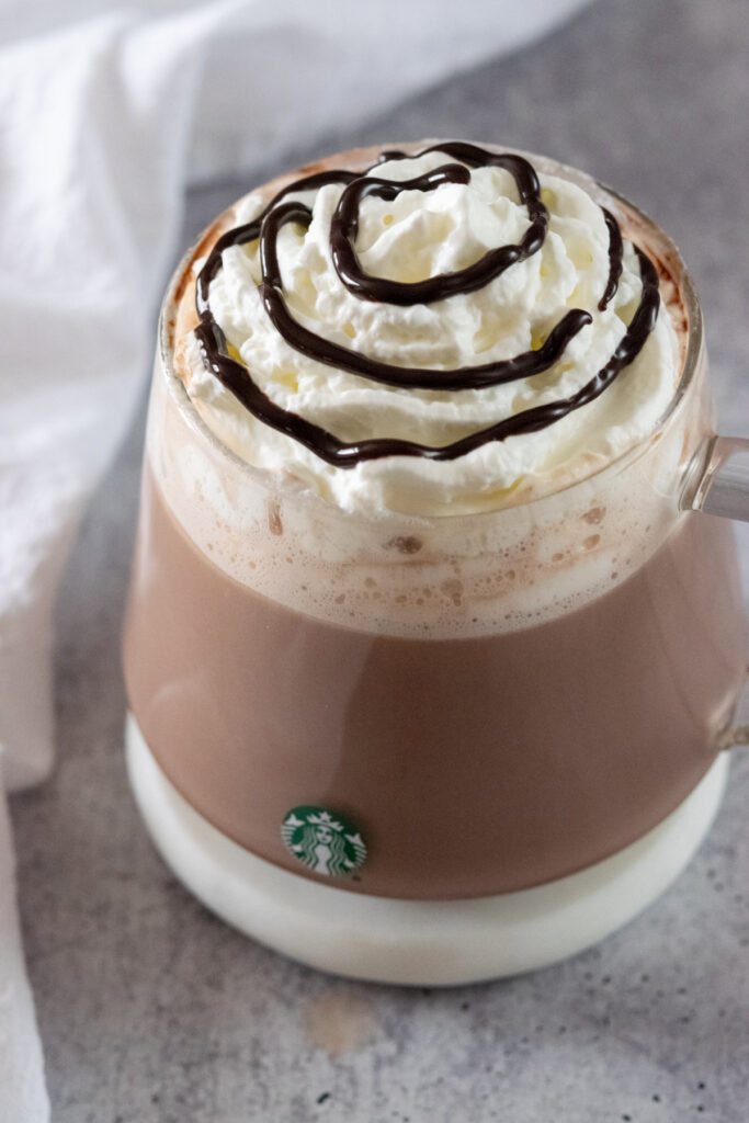 Starbucks copycat hot chocolate in glass mug that has a green Starbucks logo.