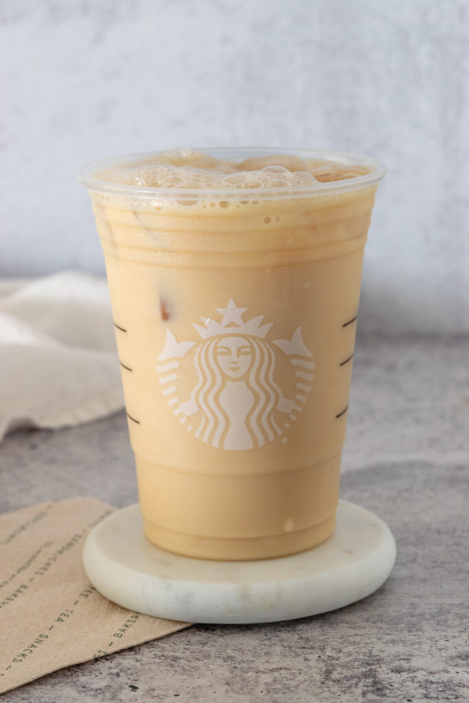 A homemade Starbucks Iced London Fog tea latte in a Starbucks cup.