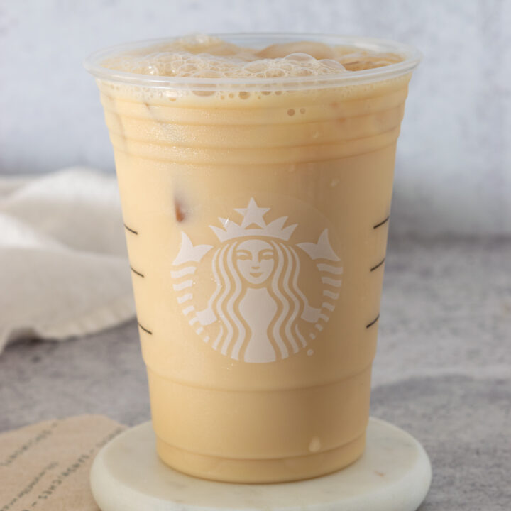 A homemade Starbucks Iced London Fog tea latte in a Starbucks cup.