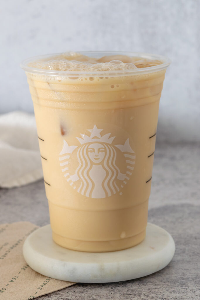 A homemade Starbucks Iced London Fog sitting on a white coaster which is sitting on a Starbucks napkin.