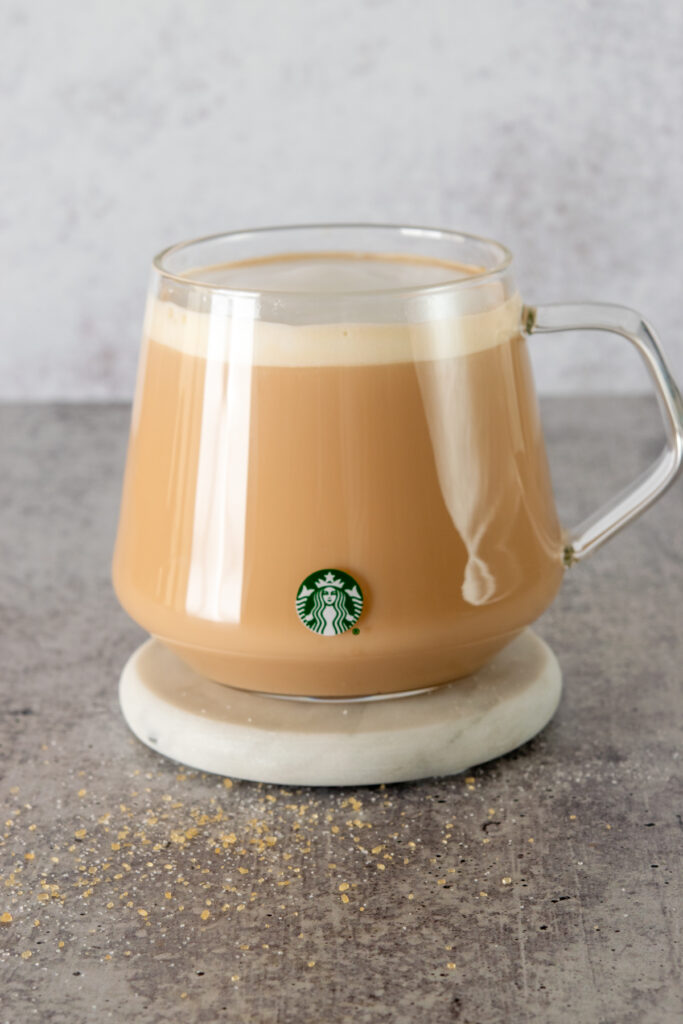 A homemade Starbucks Royal English Breakfast tea latte in a glass mug with Starbucks logo.
