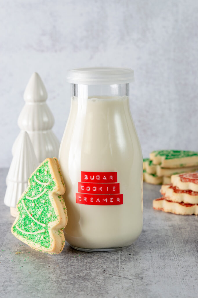 Homemade sugar cookie coffee creamer with Christmas sugar cookies next to bottle of creamer.