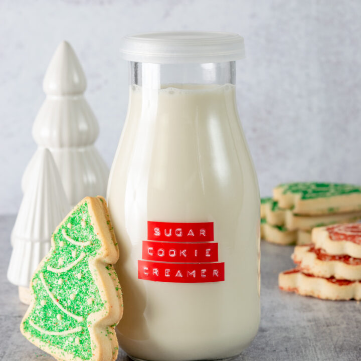 Homemade sugar cookie coffee creamer with Christmas sugar cookies next to bottle of creamer.