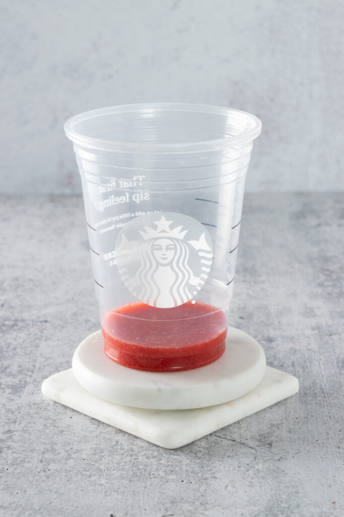 Starbucks cup with strawberry puree added to first bump in cup.