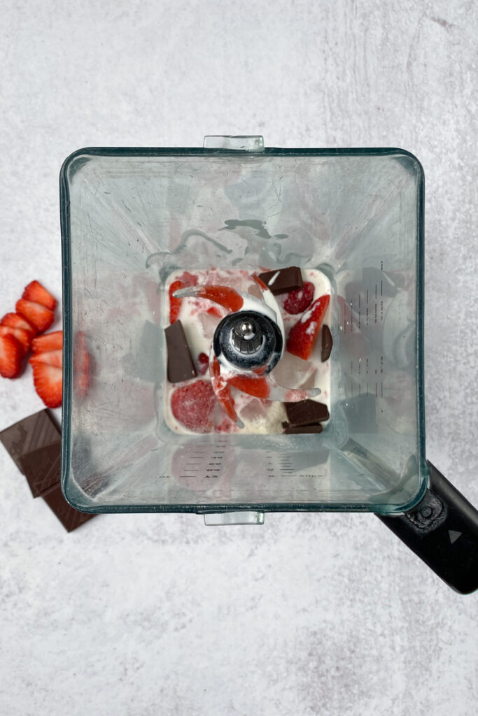 Overhead picture showing all the strawberry frappuccino ingredients inside the blender.