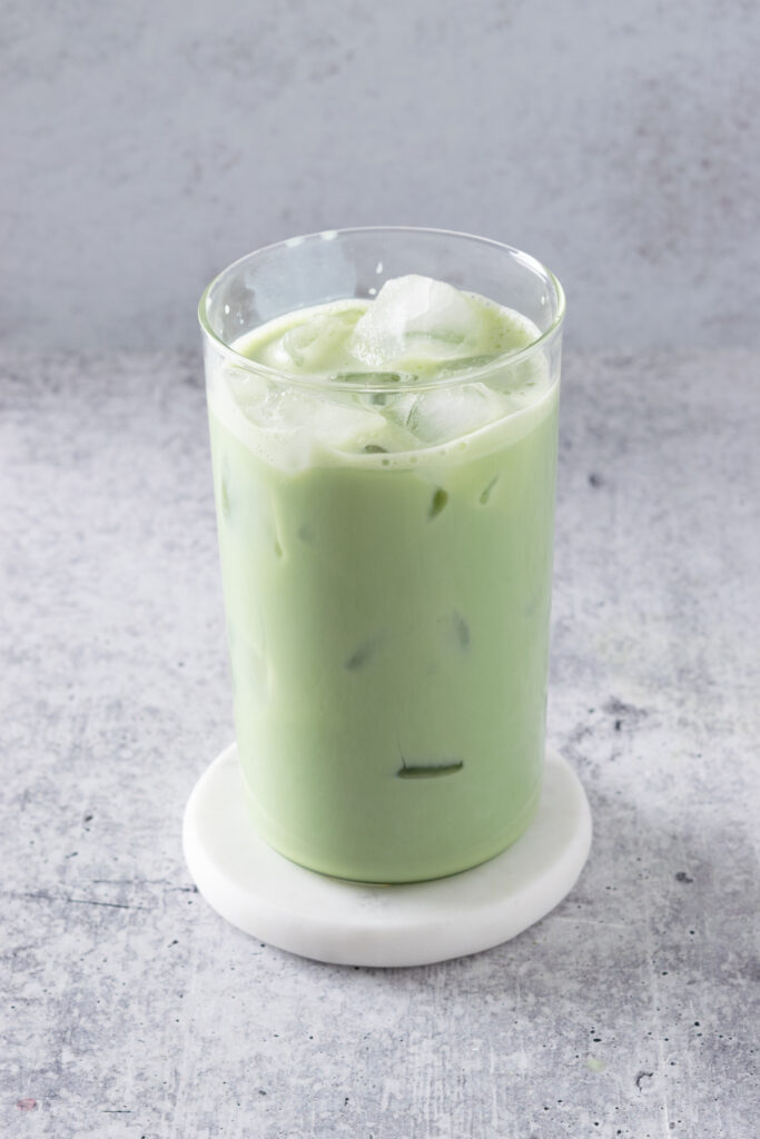 Ice added to matcha latte, leaving an inch of space at the top.
