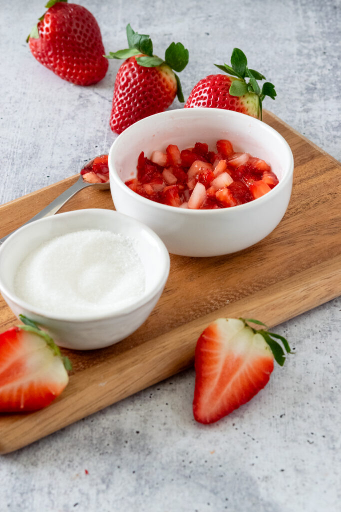 Small bowl of macerated strawberries with lots of strawberry juice.