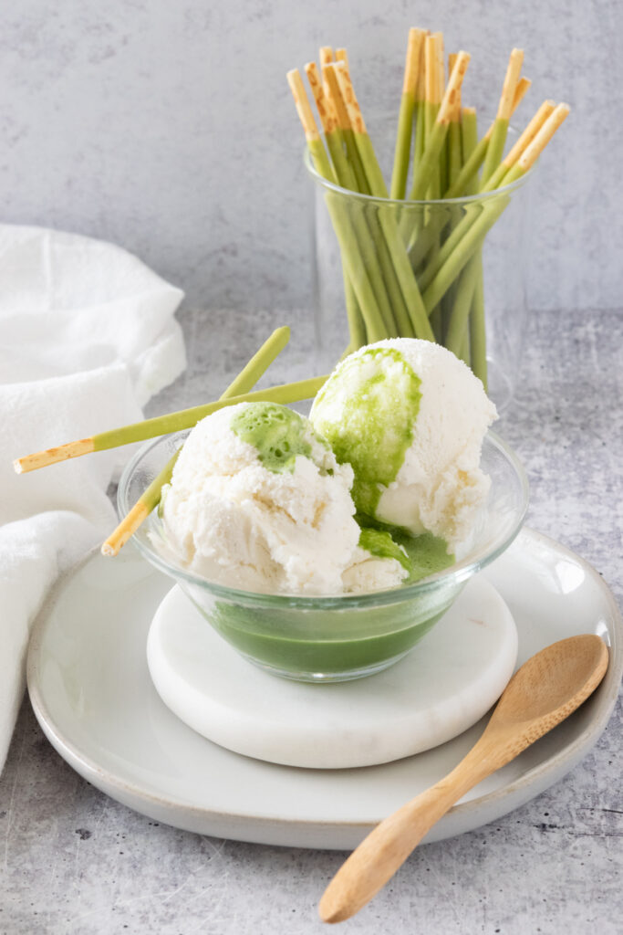 Matcha Affogato with vanilla ice cream in a small bowl with matcha green tea poured over it.