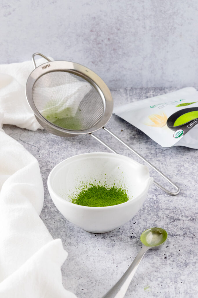 A small bowl of sifted matcha and a fine-meshed strainer.