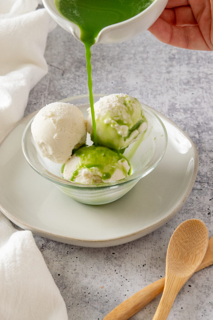 Matcha green tea being poured over vanilla ice cream.