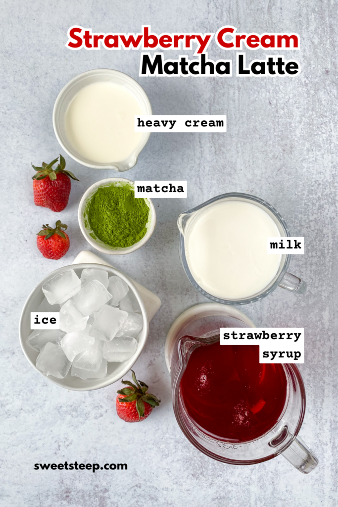 Overhead picture showing all the ingredients needed, in small bowls with three strawberries scattered throughout. There are bowls of heavy cream, milk, strawberry syrup, matcha powder and ice cubes.