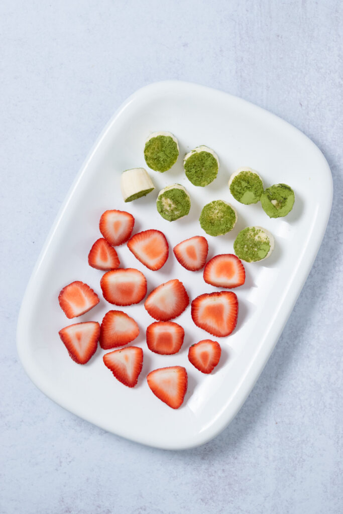 Cut up strawberries and chunks of banana dipped in matcha powder to freeze for meal-prep smoothie packs.